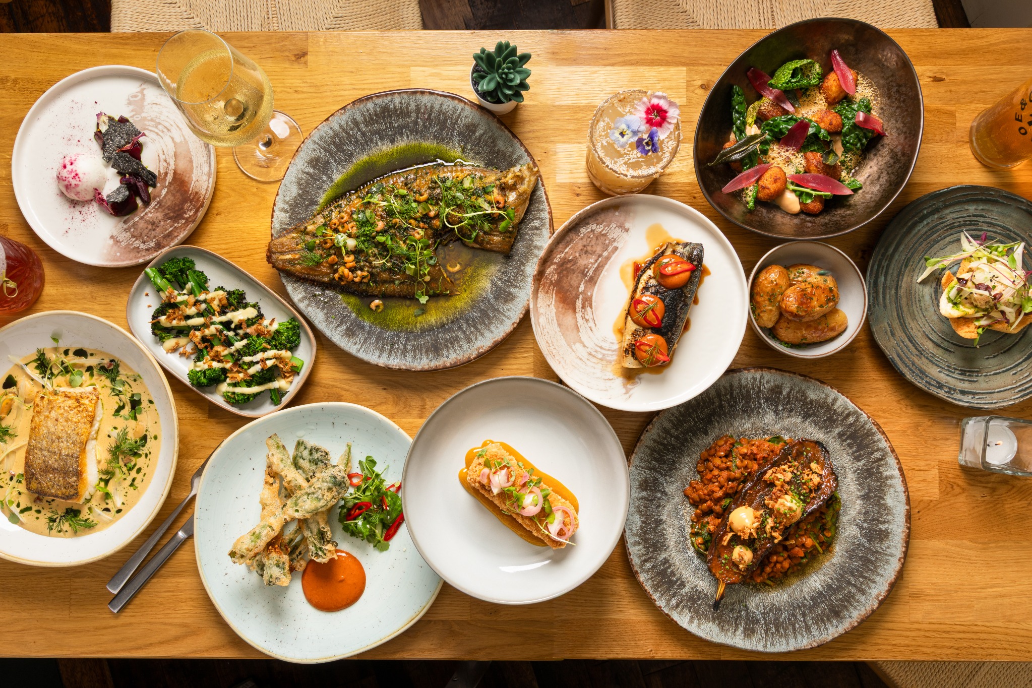 A table filled with Ginger and Joe small plates and cocktails